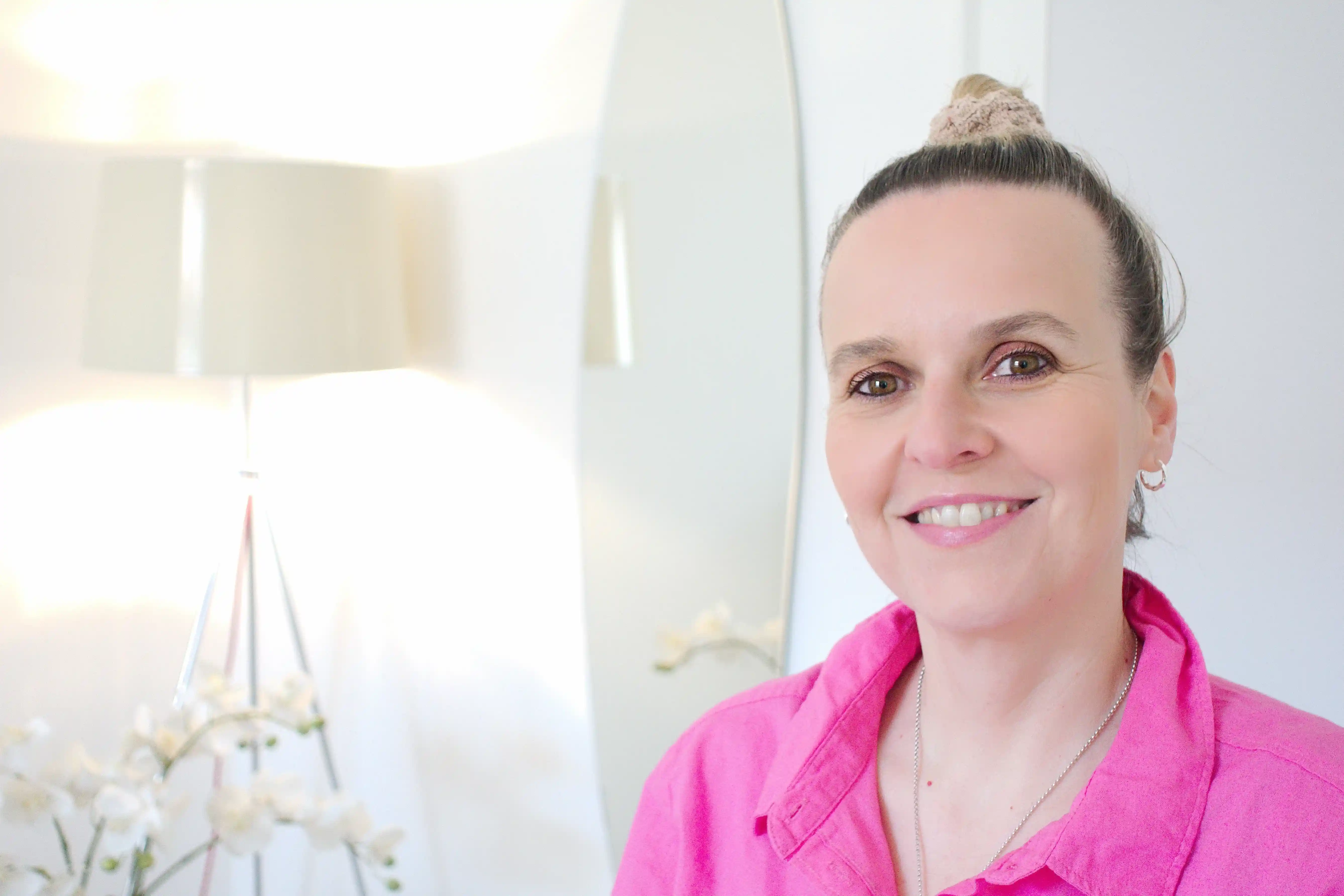 Porträt einer lächelnden Frau im hellen Wohnzimmer, Homeoffice-Coaching